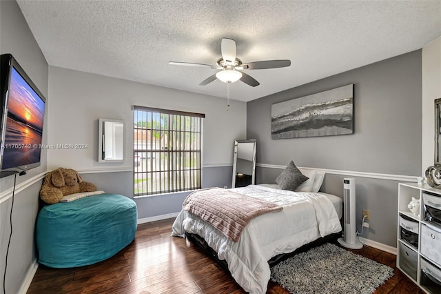 bedroom with a textured ceiling, ceiling fan, and dark hardwood / wood-style floors