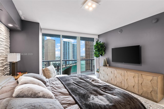 bedroom with expansive windows and access to outside