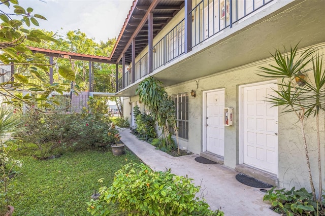 view of exterior entry with a balcony