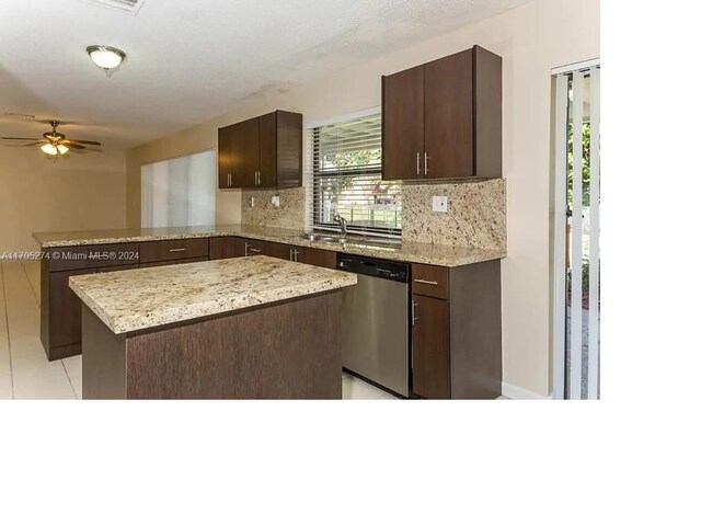 kitchen featuring stainless steel dishwasher, a kitchen island, kitchen peninsula, and tasteful backsplash