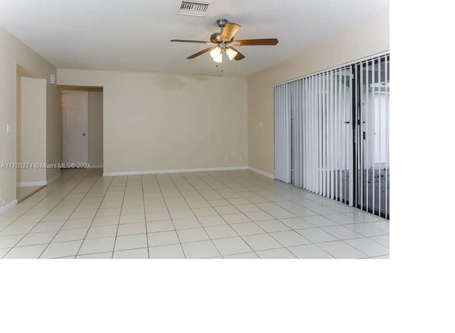 tiled spare room featuring ceiling fan