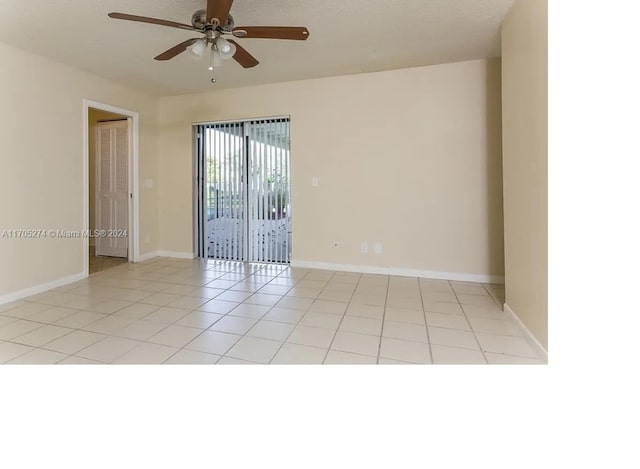 spare room with ceiling fan and light tile patterned floors