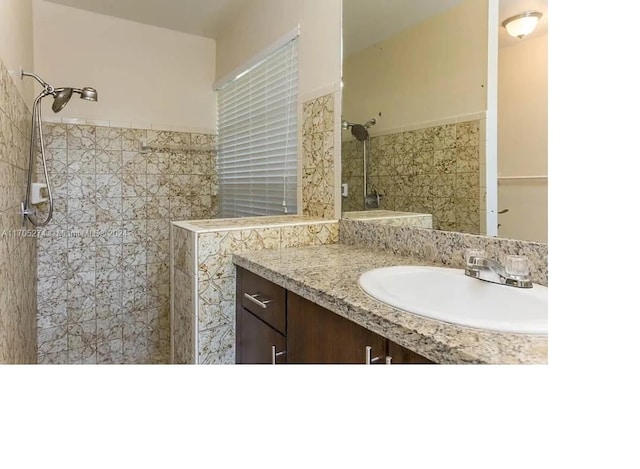 bathroom with vanity and tiled shower