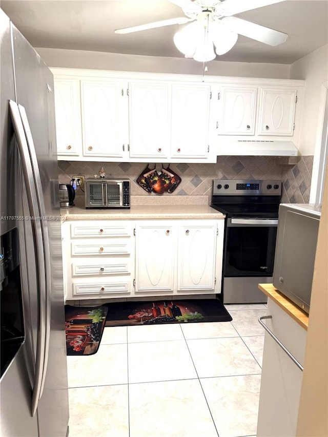 kitchen featuring ceiling fan, light tile patterned floors, tasteful backsplash, white cabinets, and appliances with stainless steel finishes