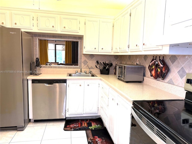 kitchen featuring white cabinets, sink, light tile patterned floors, tasteful backsplash, and stainless steel appliances