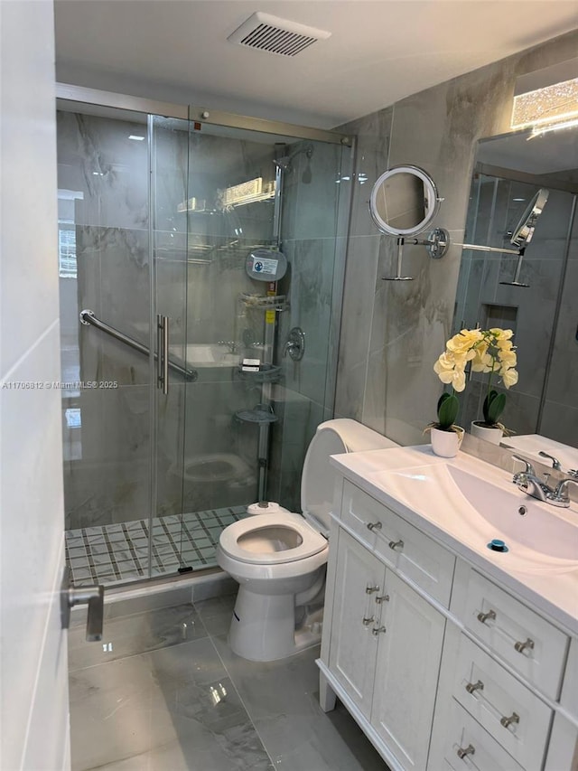 bathroom with vanity, toilet, an enclosed shower, and tile walls