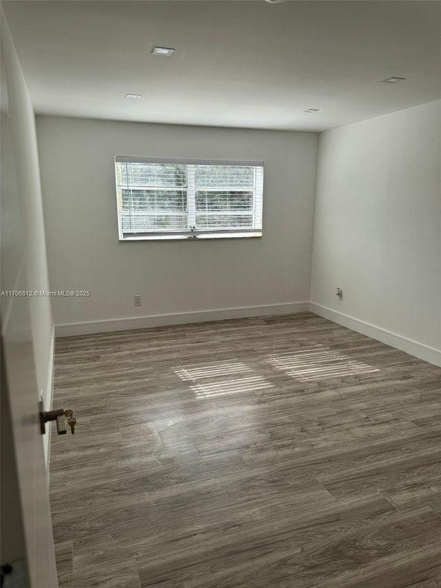 empty room with dark hardwood / wood-style flooring