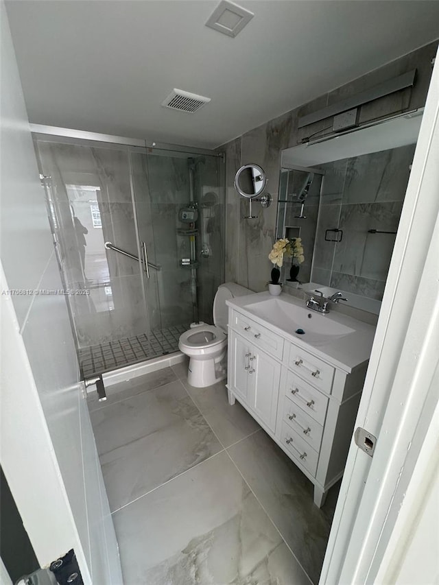 bathroom featuring vanity, toilet, and a shower with door