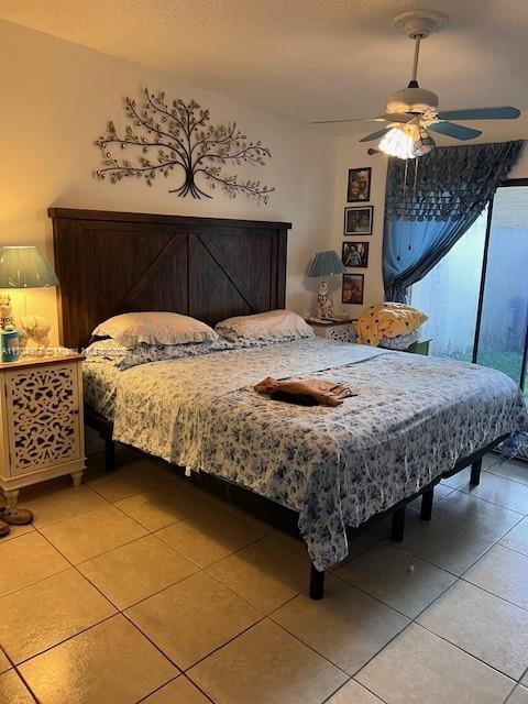 bedroom featuring tile patterned flooring, a textured ceiling, and ceiling fan