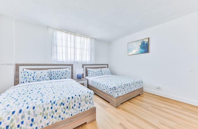 bedroom featuring a textured ceiling and hardwood / wood-style flooring