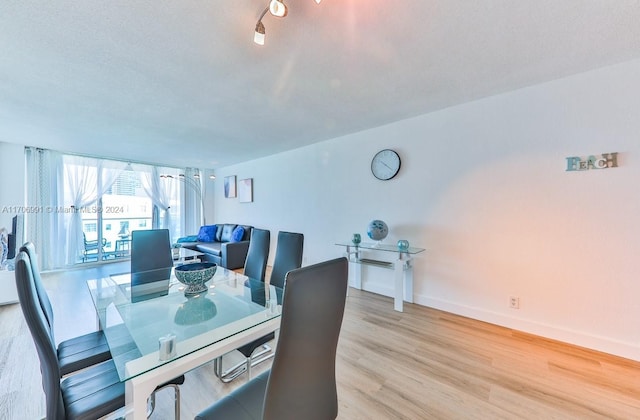 dining space featuring a textured ceiling and light hardwood / wood-style flooring