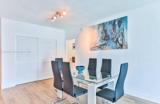 dining room with light hardwood / wood-style flooring and a textured ceiling