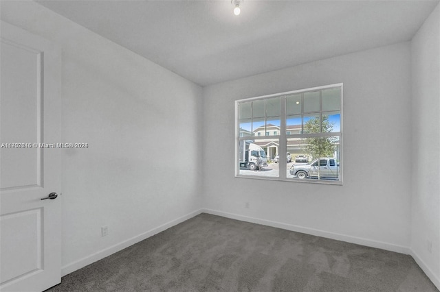 unfurnished room with dark colored carpet