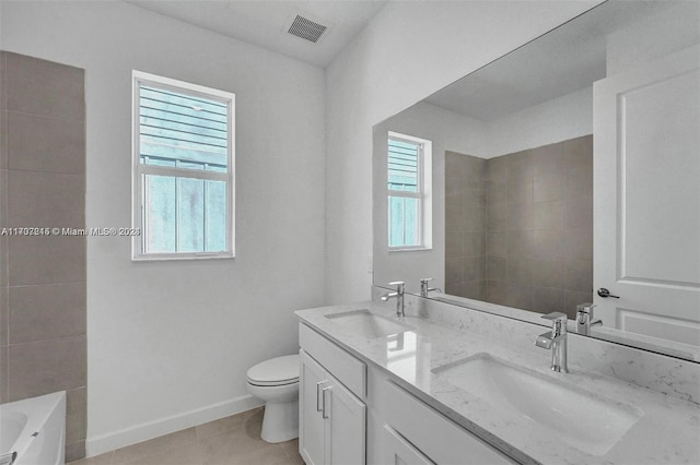 bathroom featuring tile patterned floors, a tub, vanity, and toilet