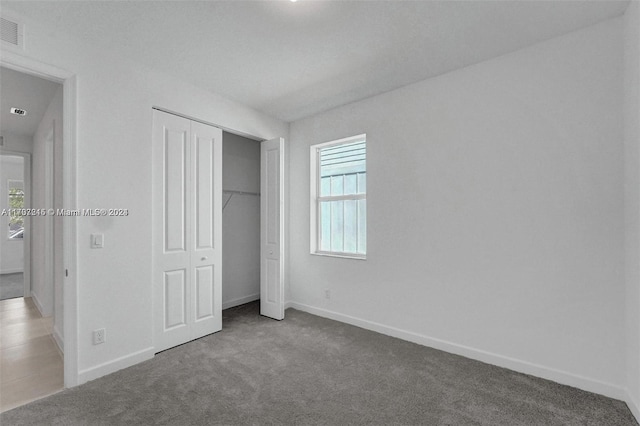 unfurnished bedroom featuring carpet floors and a closet