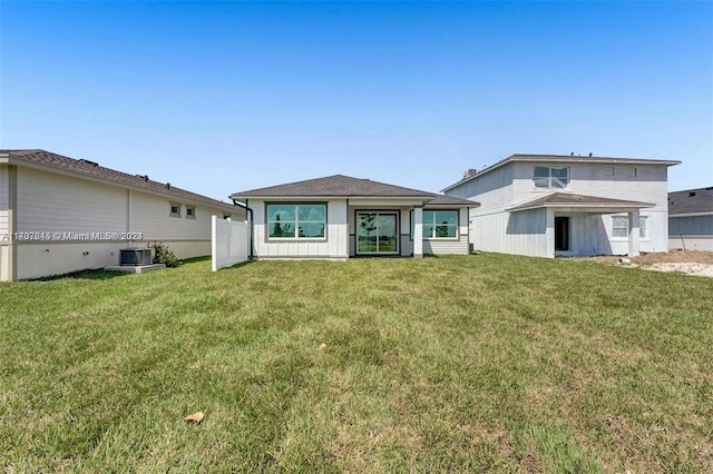 back of house with a lawn and central AC unit