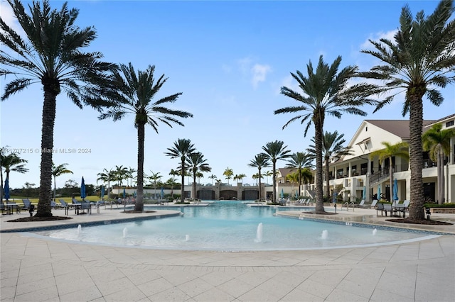 view of swimming pool featuring pool water feature and a patio area