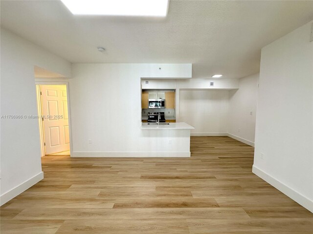 hall featuring light wood-type flooring and sink