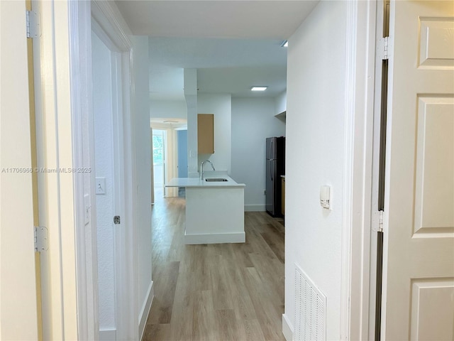 hall featuring sink and light hardwood / wood-style floors