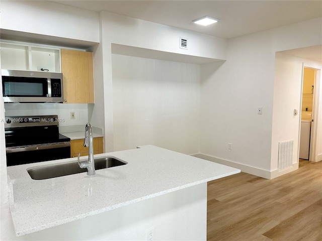 kitchen with a sink, visible vents, modern cabinets, and stainless steel appliances