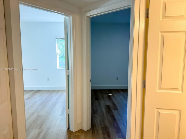 hall with baseboards and wood finished floors