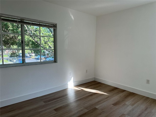 empty room featuring baseboards and wood finished floors