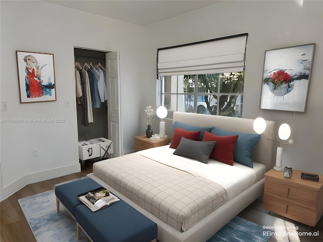 bedroom with wood finished floors, baseboards, and a closet