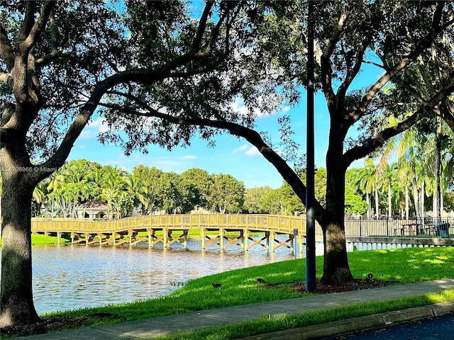 view of community with fence and a water view