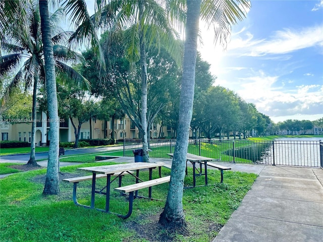 view of property's community with a yard, fence, and a gate