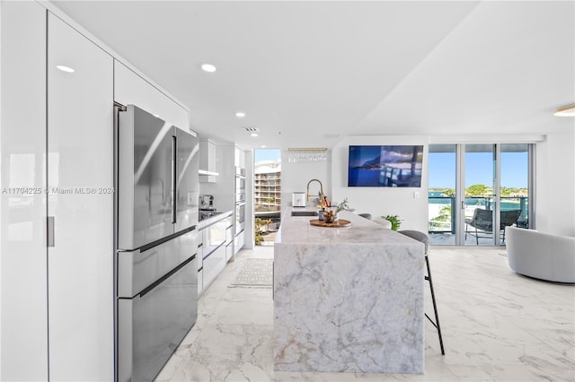 kitchen featuring a healthy amount of sunlight, white cabinetry, sink, and appliances with stainless steel finishes