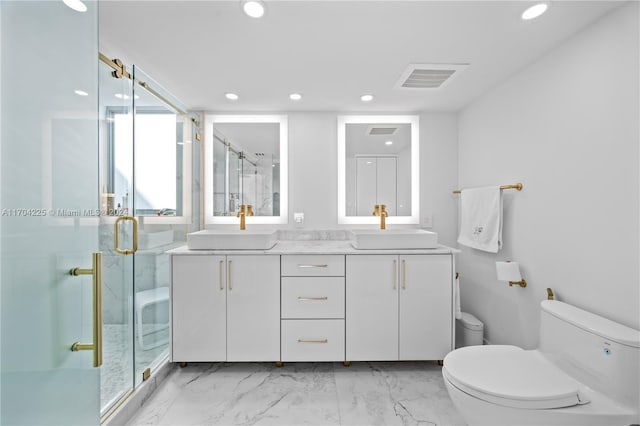 bathroom with vanity, toilet, and a shower with door