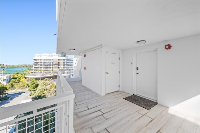 entrance to property featuring a water view and a balcony