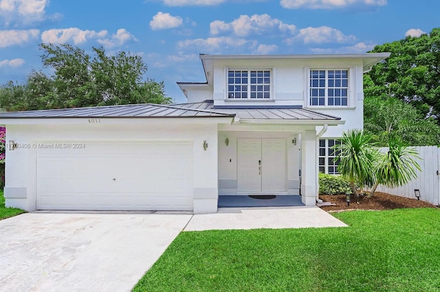 view of front of property featuring a front yard and a garage