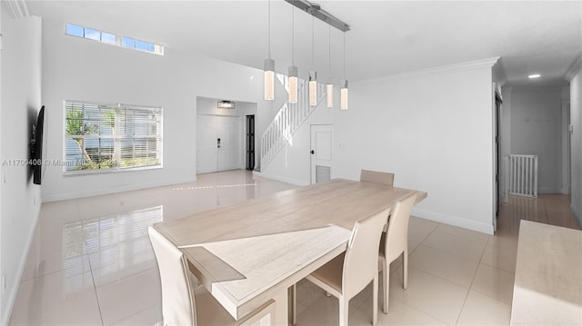 dining space with light tile patterned floors and crown molding