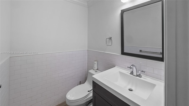 bathroom with vanity, toilet, and tile walls