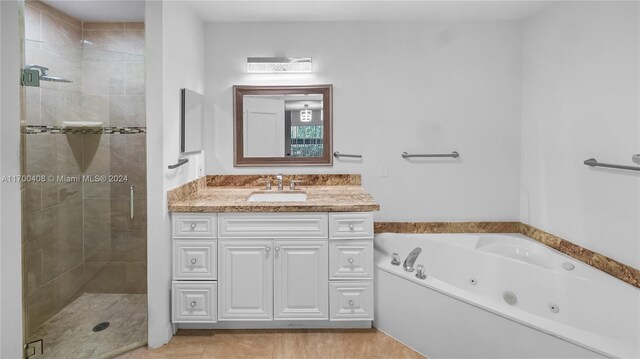 bathroom featuring plus walk in shower, vanity, and tile patterned floors