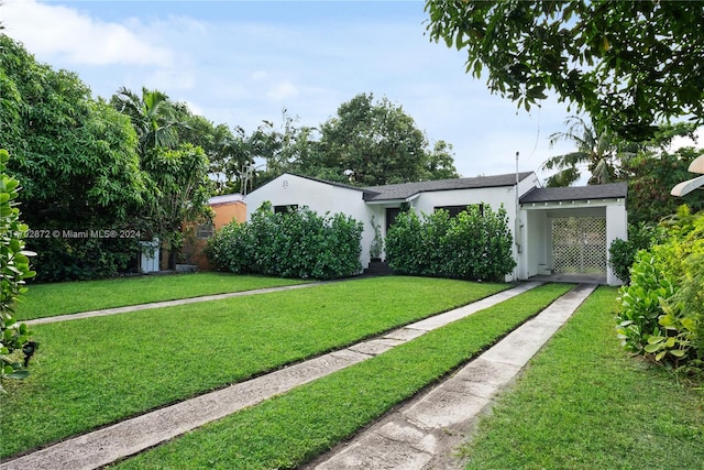 view of front facade featuring a front yard and a carport