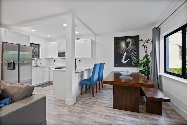 kitchen featuring white cabinets, light hardwood / wood-style floors, and stainless steel appliances