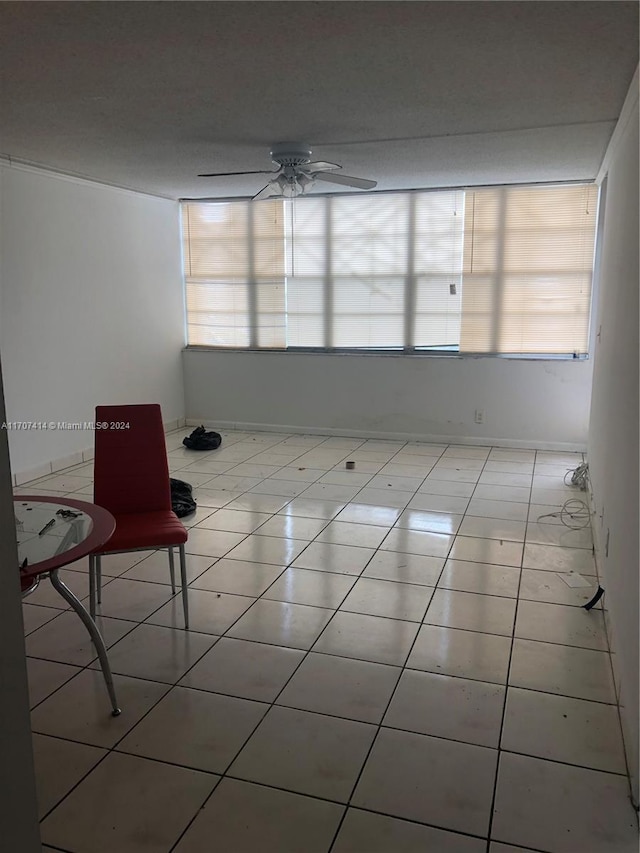 tiled empty room featuring ceiling fan