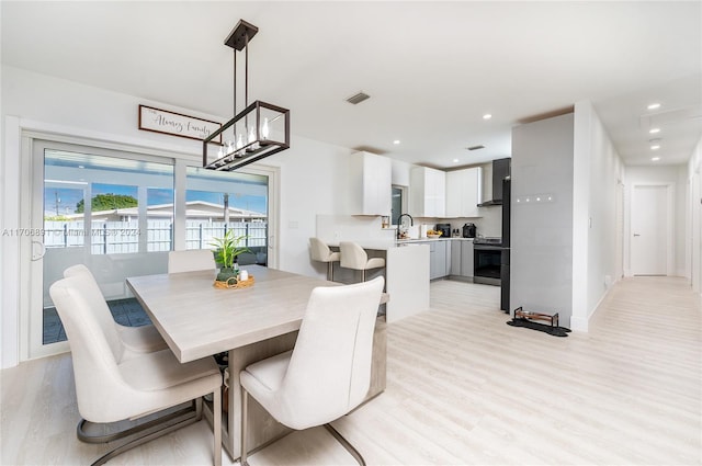 dining area with sink and light hardwood / wood-style flooring