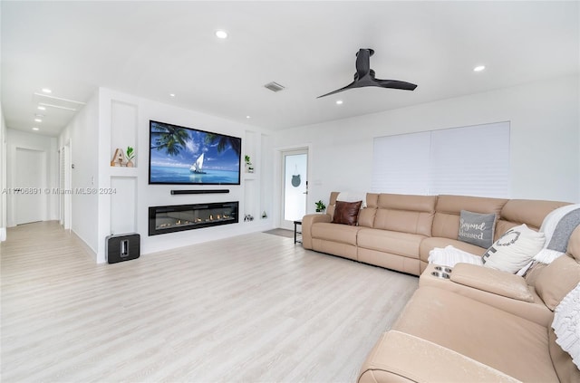 living room with ceiling fan and light hardwood / wood-style flooring