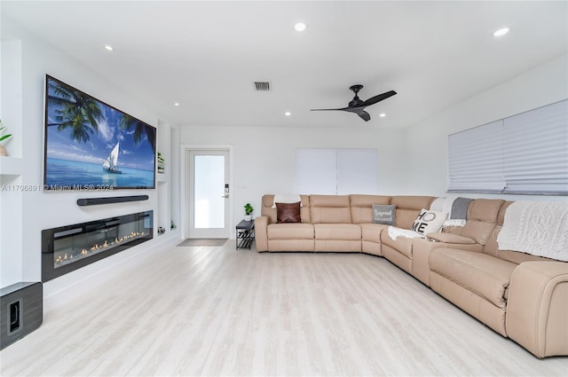 living room featuring ceiling fan and light hardwood / wood-style flooring