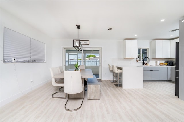 dining area with light hardwood / wood-style flooring and sink