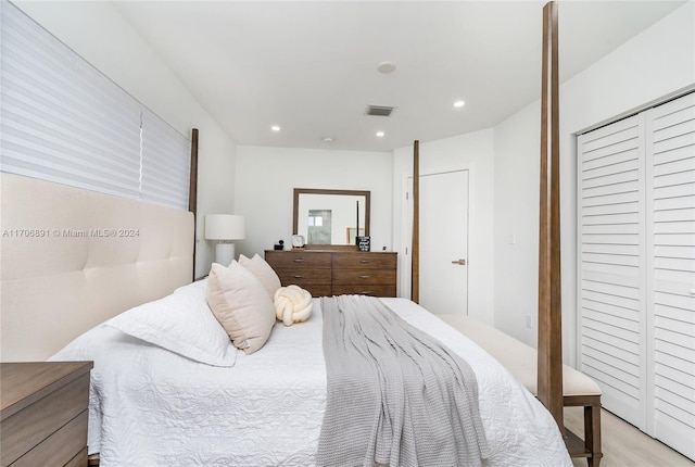 bedroom with light hardwood / wood-style floors and a closet