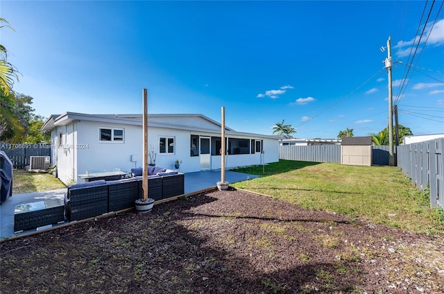 rear view of property with a yard, a storage unit, an outdoor hangout area, central AC unit, and a patio