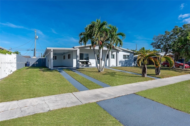 view of front of home with a front lawn and a carport