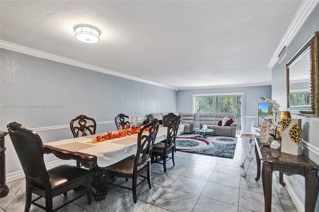 dining room with ornamental molding and a textured ceiling