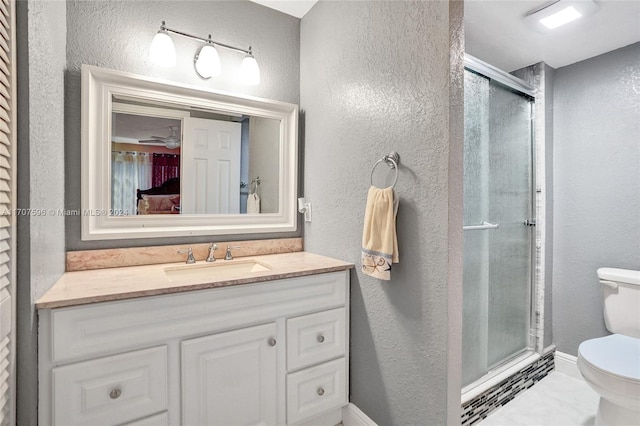 bathroom featuring vanity, toilet, and a shower with shower door