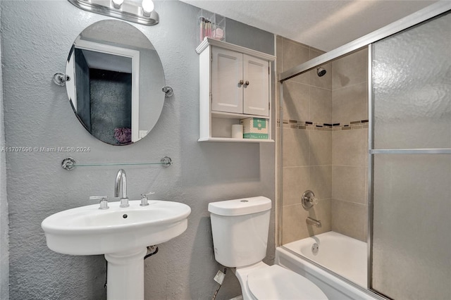 bathroom featuring shower / bath combination with glass door and toilet