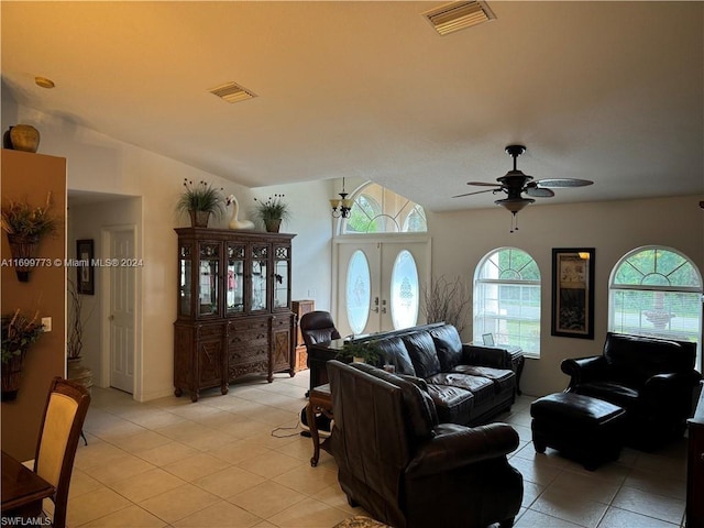 living room with ceiling fan, vaulted ceiling, light tile patterned floors, and french doors